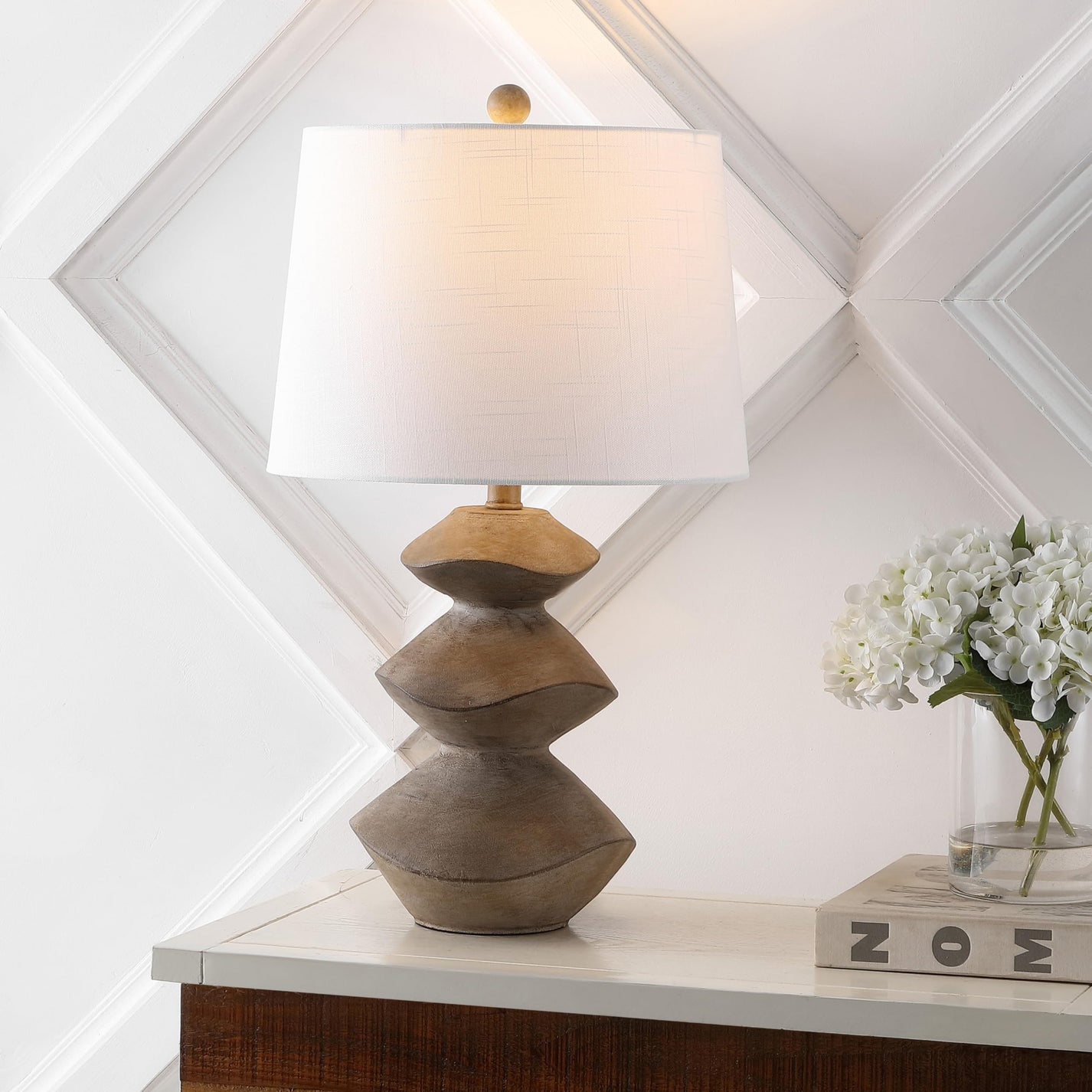 Sculptural table lamp with white shade, ideal for decorating on a budget.