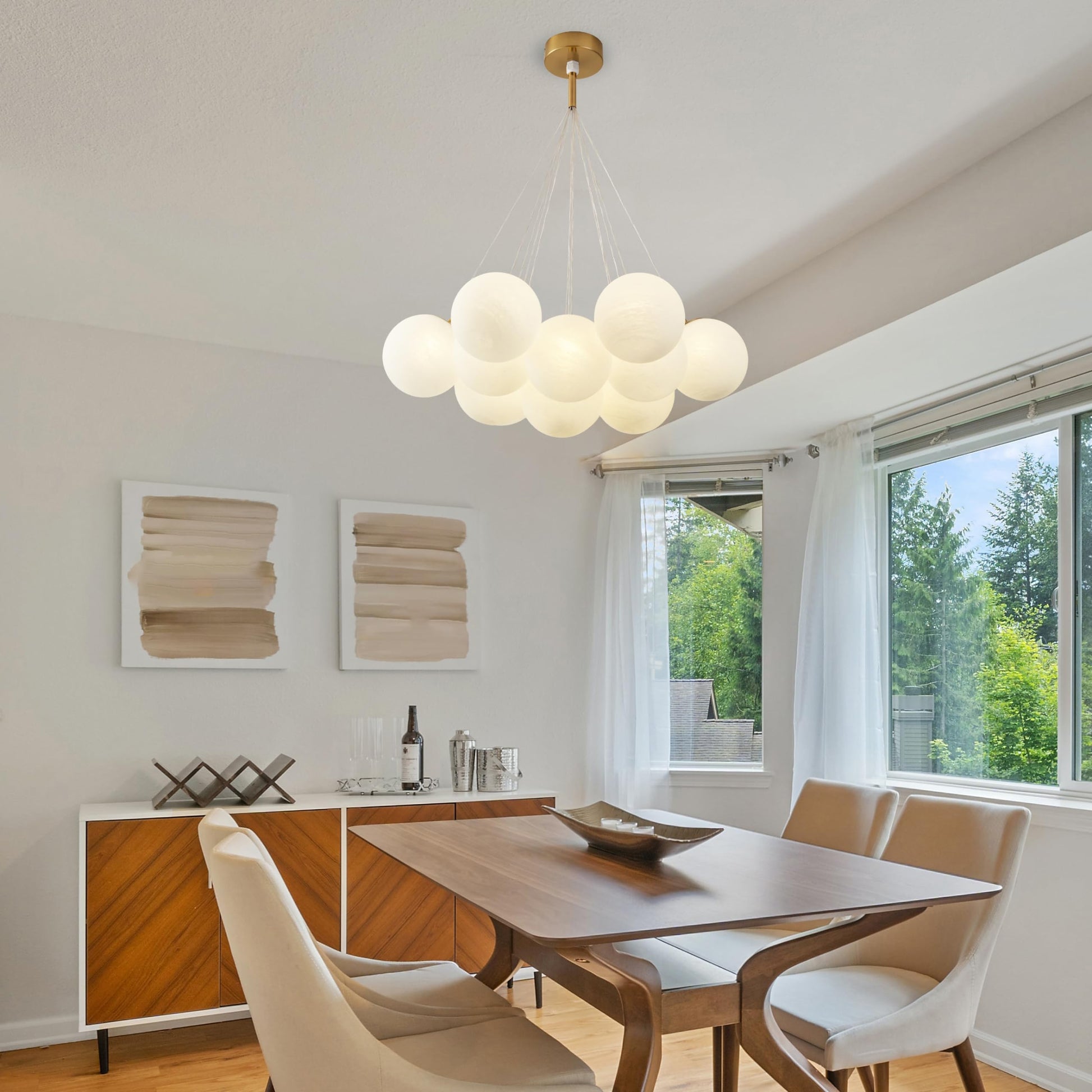 Modern dining room with wood table, cream chairs, abstract wall art, and bubble chandelier