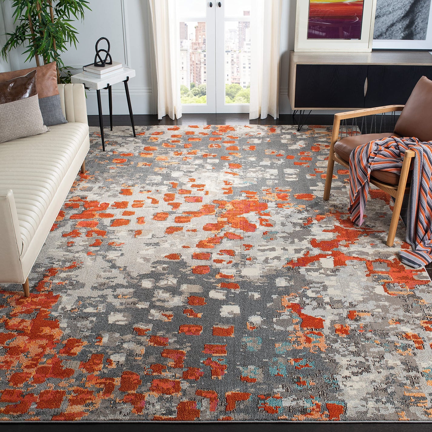 Modern grey rug w/ orange abstract pattern, perfect for decorating on a budget.